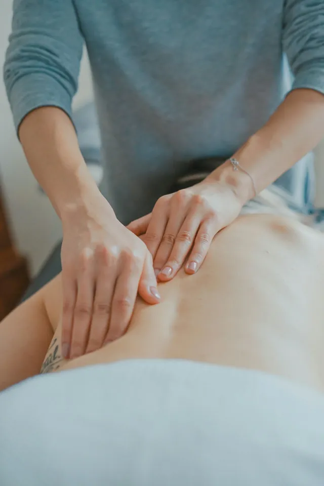 Hands massaging a patient's lower back